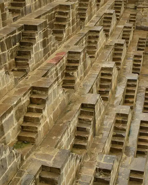 Rows of criss-crossing stone steps descending inside a stepwell